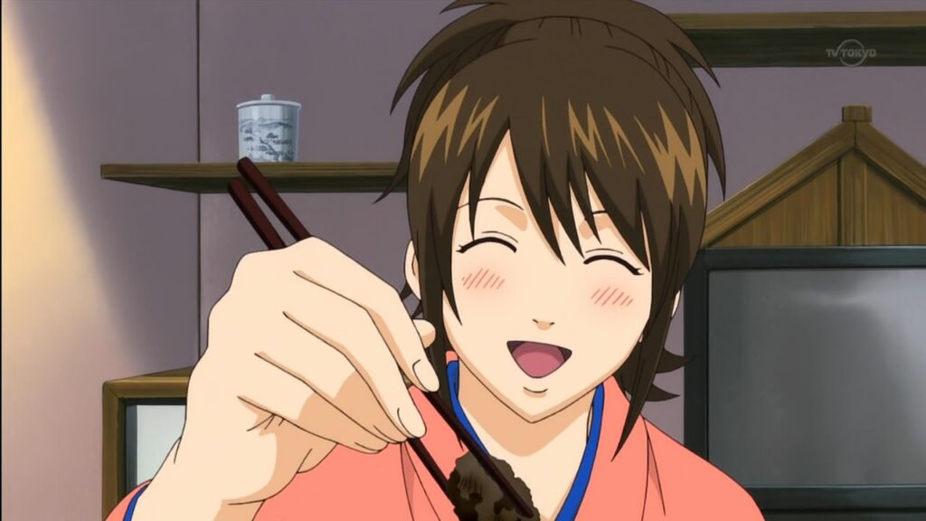Shimura Tae smiling with chop sticks.